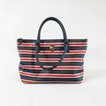 A striped tote bag with a black handle and zipper.