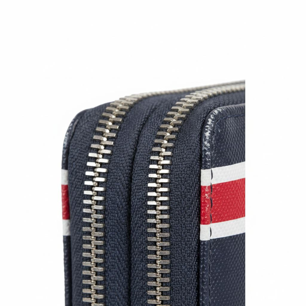 A close-up view of a black and red striped wallet or purse with a zipper closure.